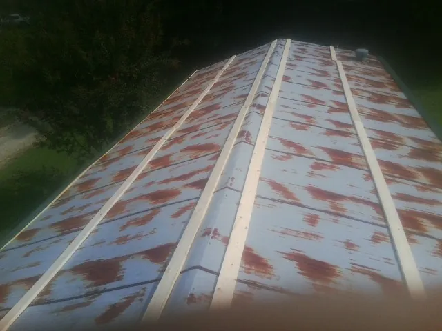 Rusted metal roof panels with new wood purlins before replacement — Storm Damage Roof Repair in Risingsun by Roofing Brothers