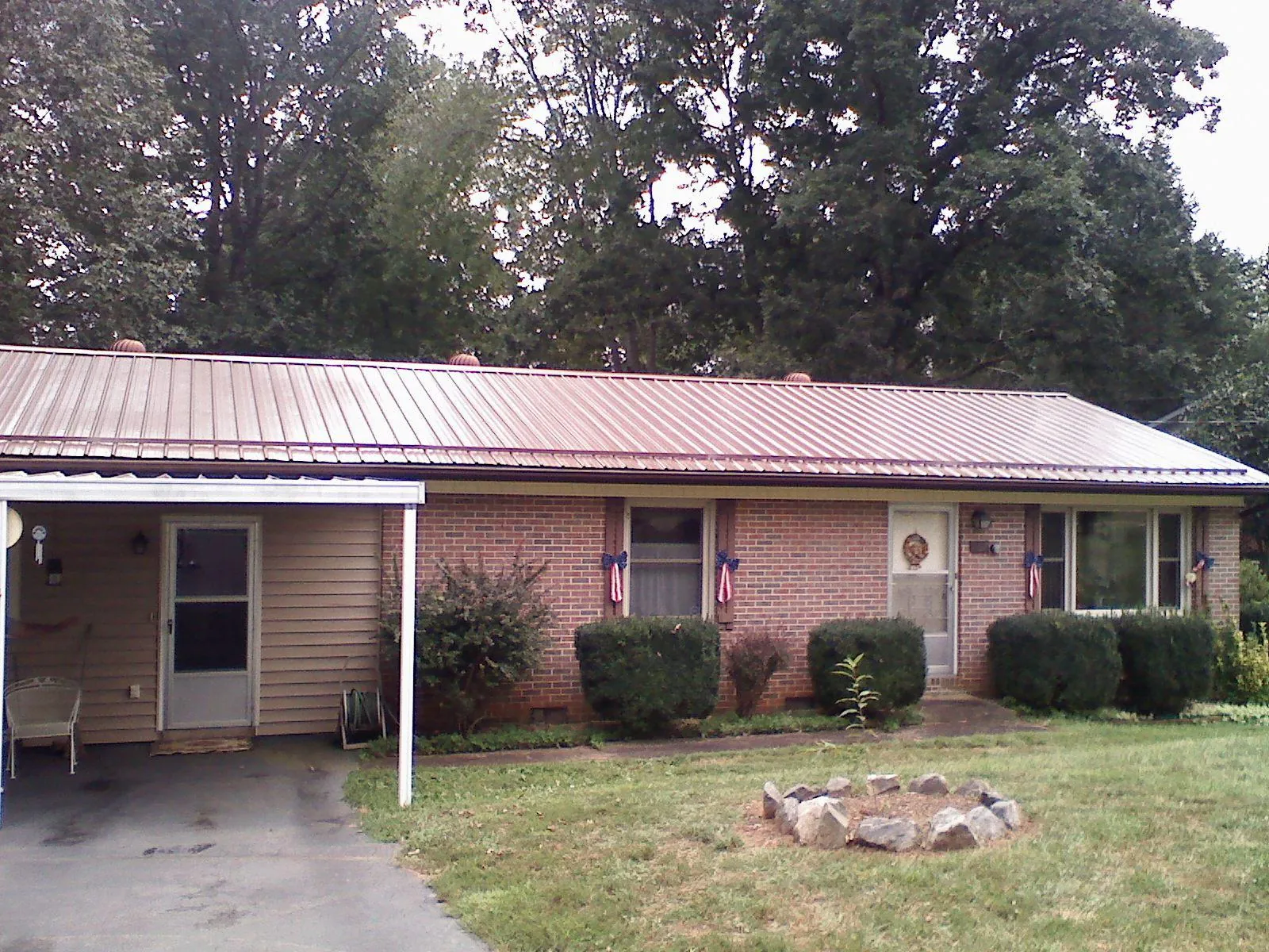 Bronze metal roof and carport on a brick ranch home — Roof Repair work by our crew in Risingsun